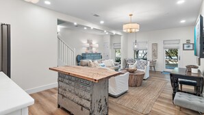 A spacious living area with a wooden coffee table, a white sofa, and a blue cabinet.