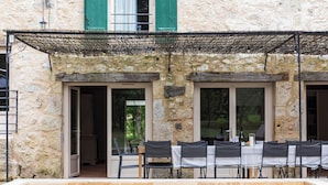 Un bâtiment en pierre doté d’une piscine, d’un espace extérieur aménagé et d’un patio couvert.