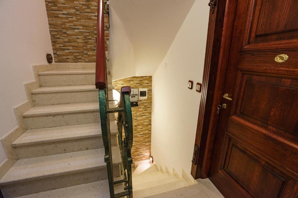 A staircase leading to a room with a wooden door and a stone wall.
