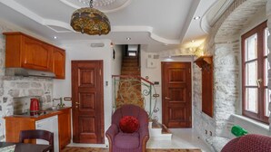 Un intérieur chaleureux comprenant une cuisine, un coin repas et un escalier menant à un niveau supérieur.