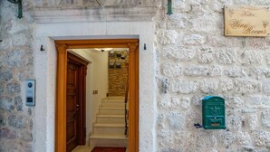 Un mur de pierres sur lequel est apposée une plaque indiquant « Keller Wine Rooms » et une boîte aux lettres verte.