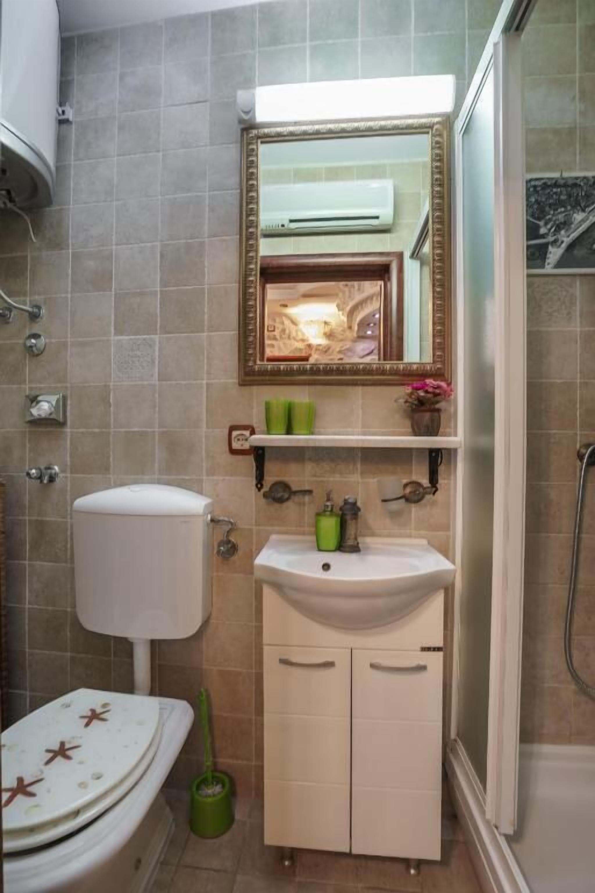 A bathroom with a toilet, sink, and shower.