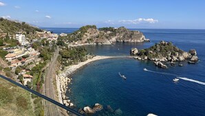Une ville côtière offrant une vue dégagée sur la mer, avec des affleurements rocheux et des bâtiments qui bordent la côte.