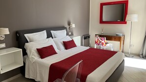 Une chambre bien rangée, avec un lit, des tables de chevet, une chaise, un bureau et un miroir.