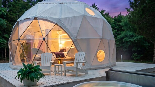 Une structure en forme de dôme géodésique dotée d’un jacuzzi et d’un espace de détente extérieur.