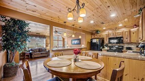 A wooden interior with a dining area, kitchen, and living space. - Cabin in the Valley! Easy Access! Pet Friendly! (Sevierville)