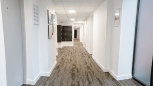 A hallway with white walls, a patterned carpet, and framed pictures on the walls. - Contemporary 1 Bed Apartment in Central Liverpool (Liverpool)