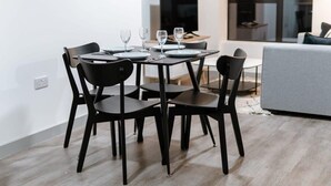 A modern dining area with a rectangular table, black chairs, and a grey sofa in the background. - Contemporary 1 Bed Apartment in Central Liverpool (Liverpool)