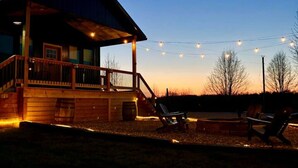 A wooden cabin with a balcony and string lights.