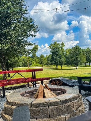 Un hogar de piedra con bancos y una mesa de picnic en un parque.