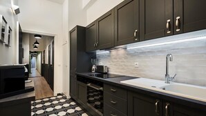 Una cocina moderna con armarios oscuros, una encimera blanca y un salpicadero de azulejos.