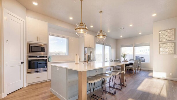 A modern kitchen with stainless steel appliances, a central island with bar stools, and pendant lighting. - Private Pool & Hot Tub • Rooftop Fire Pit • Sleeps 20 • Near Zion (Washington)