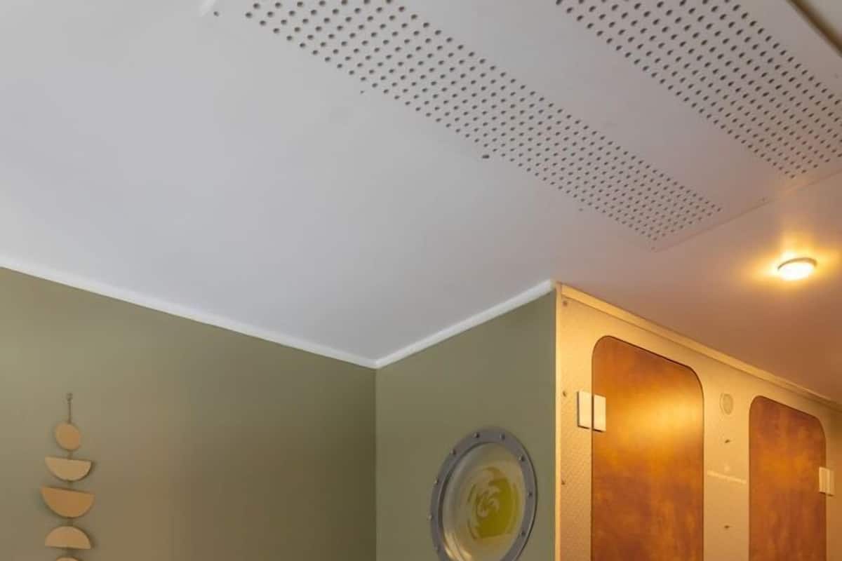Una habitación con cama, una mesa de madera, una silla, un armario y un adorno circular en la pared.