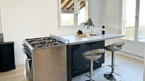 Een moderne keuken met een gasfornuis, een bar en een groot raam.