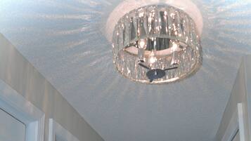 Un corridoio con un lampadario, una porta e vista all'esterno.