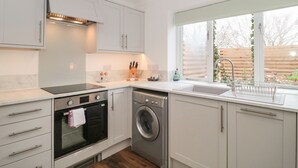 Una cocina moderna con electrodomésticos integrados, un ventanal y vistas al exterior.