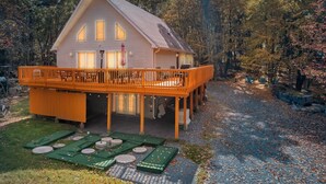 Ein zweistöckiges Haus mit Balkon, umgeben von Bäumen.