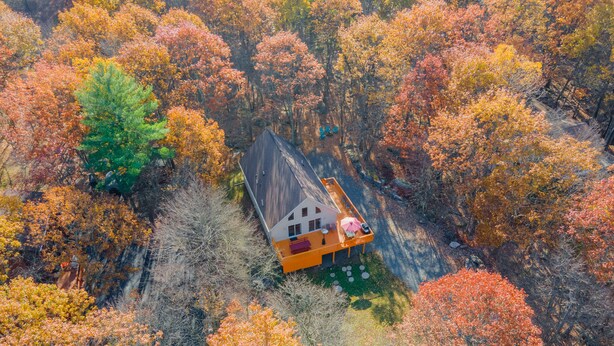 Luftaufnahme eines Hauses, umgeben von Herbstlaub.
