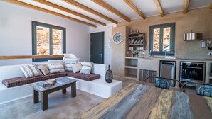 Eine moderne Küche mit integrierten Geräten und einem Essbereich mit Holztisch und Bänken.