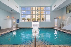 A swimming pool with a clear view of the sky and a building in the background.