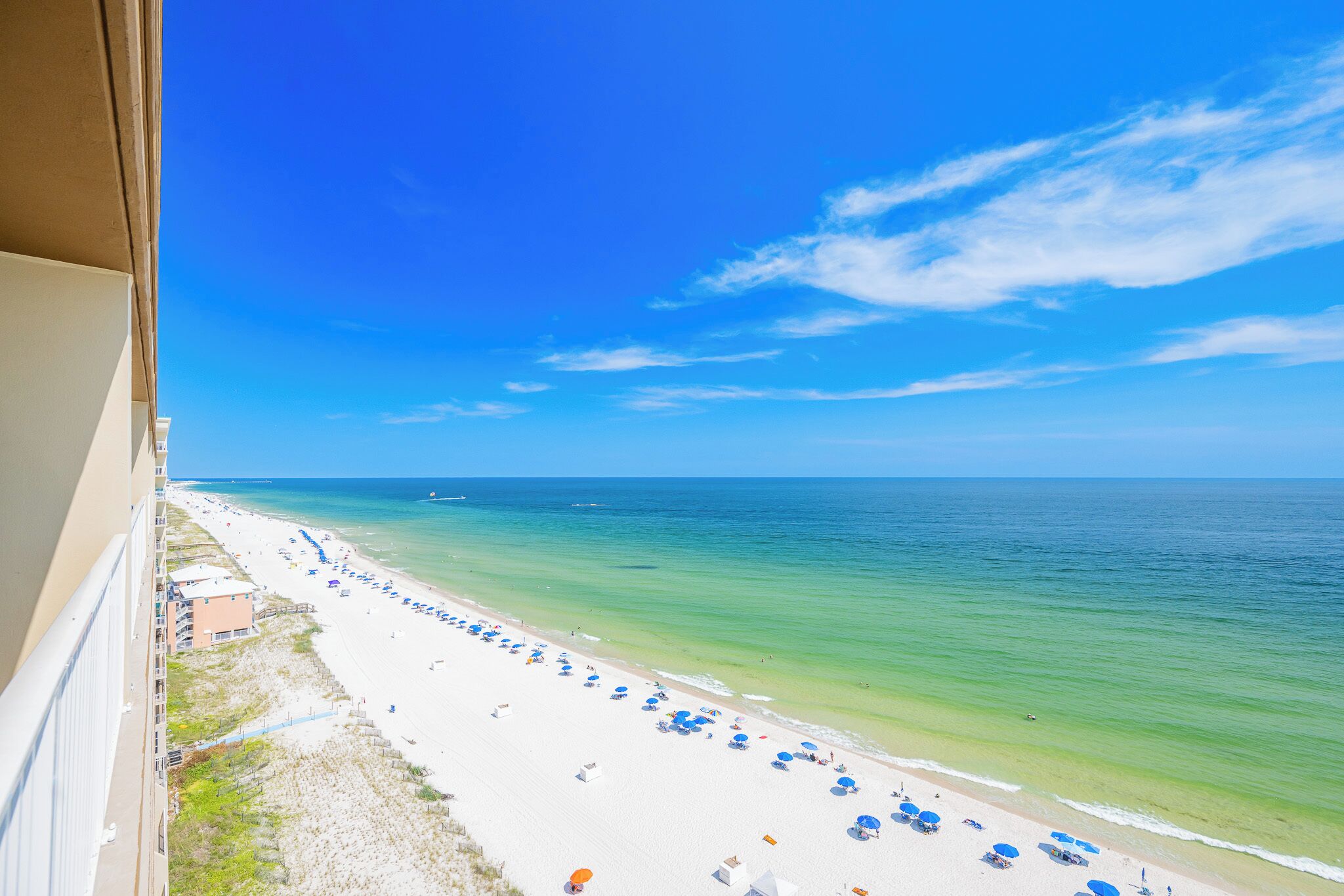 A beach with white sand, clear turquoise water, and a clear blue sky.