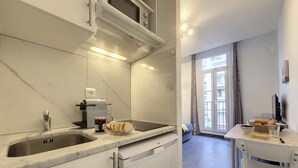 Eine kleine Küche mit Spüle, Toaster und einer Schüssel Brot.