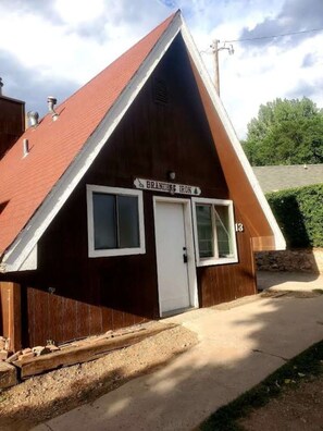 Un petit bâtiment en bois, avec un toit rouge, une enseigne indiquant « Branding Iron » et le chiffre « 13 » sur le côté.