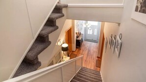 A staircase leading to a room with a wooden floor and a door leading to another room. - Starfish, city center, central location, wifi, very quiet (Norderney)
