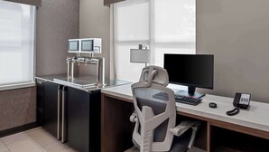 Un espacio de oficina moderno con escritorio, computadora y teléfono.