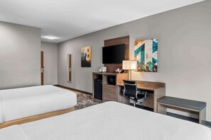A hotel room with two beds, a desk with a computer, a TV, and artwork on the wall. - Best Western San Bernardino Hotel (San Bernardino)