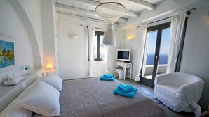 A hotel room with a large bed, a TV, a balcony with a view, and a painting on the wall. - 5 Bedroom Spectacular sunset view villa (Coressia)