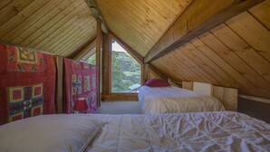 A cozy attic bedroom with two beds, wooden beams, and a view of the countryside. - Beautiful apartment in a chalet, shared sauna at the foot of the slopes (Valmorel)