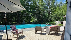 A wooden deck with a pool, surrounded by trees. - Swimmin pool movie stars &a c’ment pond- jc ma gee (Shédiac)