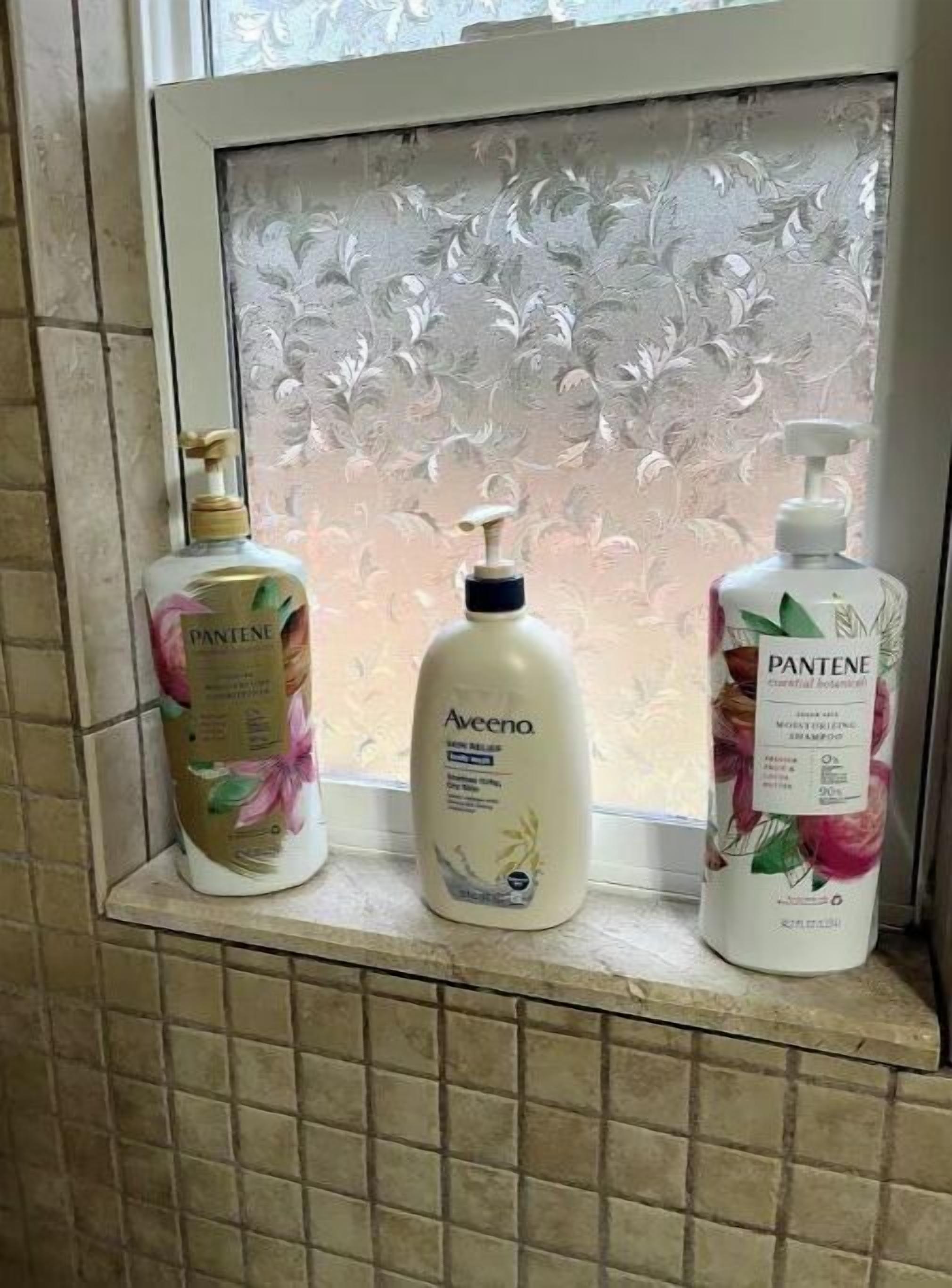 Tres productos para el cuidado del cabello Pantene sobre una repisa de baño.