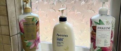 Tres productos para el cuidado del cabello Pantene sobre una repisa de baño.