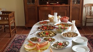 Une table à manger avec différents plats et un lustre au-dessus.