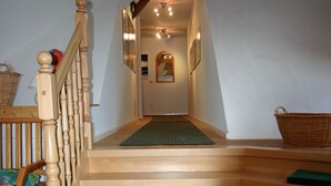 Un escalier en bois avec des marches vertes menant à un palier.