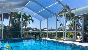 A clear blue pool with a white pool ladder and a yellow float. - Ellie’s Landing 2 – Waterfront Gem w/ 2 Masters (Port Charlotte)