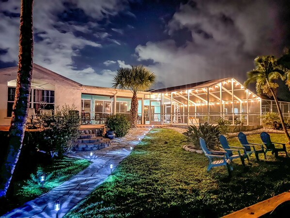 A house with a covered patio area, a pathway, and outdoor seating.