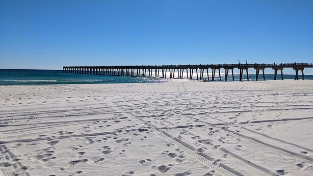 A beach with a pier extending into the ocean. - Two Couples, 2 Primary Suites, 1 BoHo GardenHouse (Pensacola)