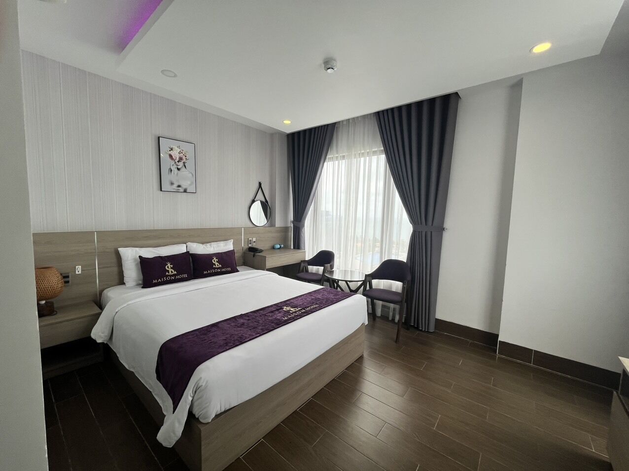 A modern hotel room with a large bed, a desk, and a chair.