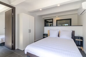 Relax in a spacious room with a large bed, wooden headboard, and stylish mirror.