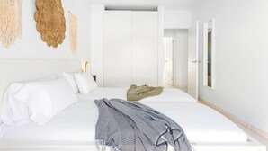 A minimalist bedroom with a large bed, a bedside table, a hanging macrame wall decor, and a wardrobe. - Family villa with private heated pool and ocean views (Tabaiba)