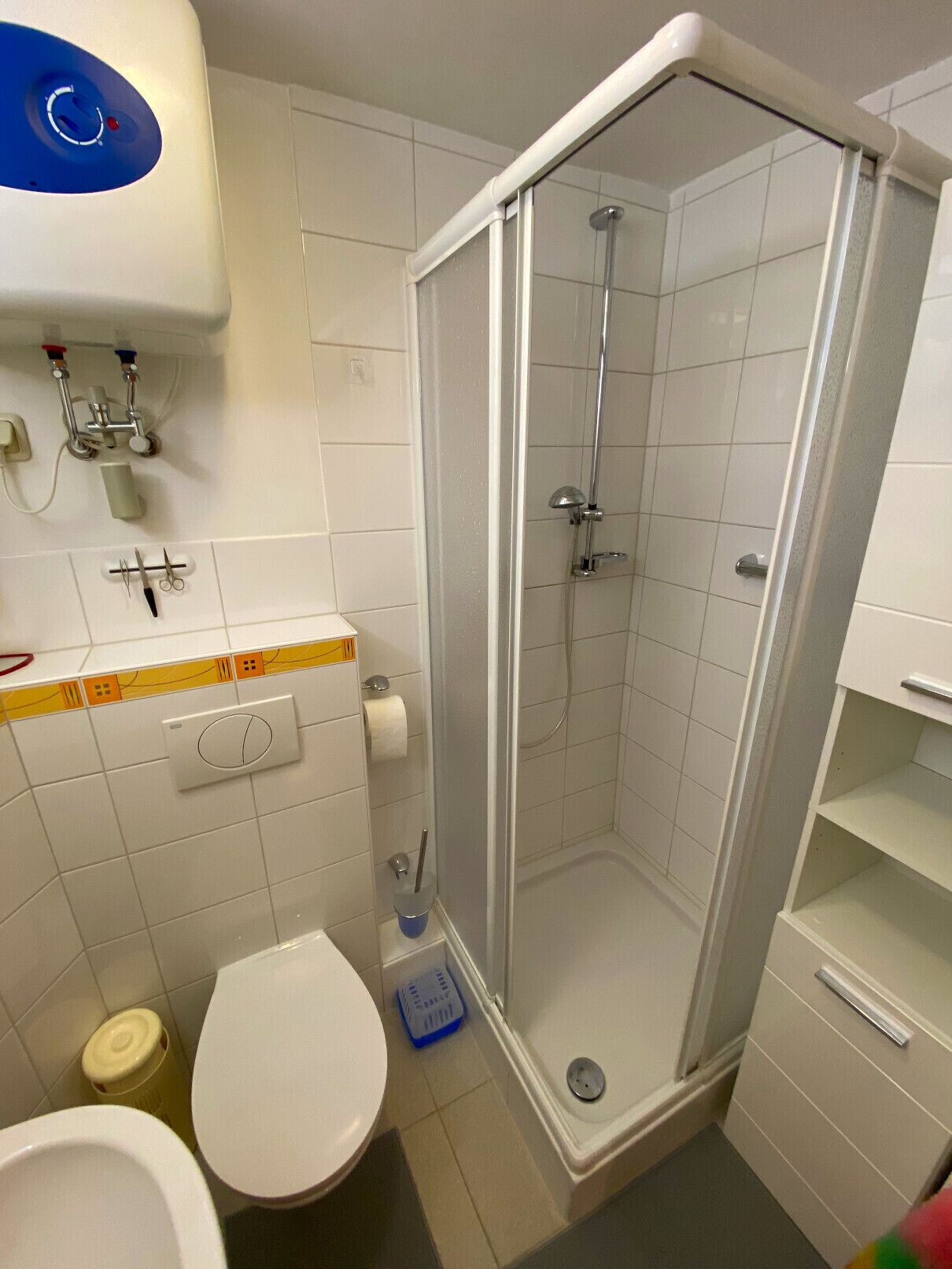 A bathroom with a shower, toilet, and sink.