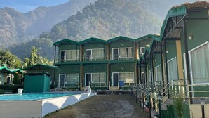 Un hôtel doté d'une piscine et offrant une vue sur les montagnes.