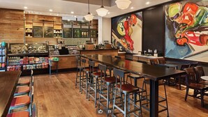 Un interno di ristorante con pareti in legno, una zona bar e un murale.