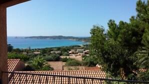 A coastal view with a clear sky, a beach, and a residential area with terracotta roofs. - Air-conditioned apartment with sea view, in a residence in the heart of a 3-hectare park (Cargèse)