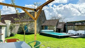A backyard with a wooden pergola, a swimming pool, and outdoor seating. - Gites-domainedupin, "gîte de la Closerie (Mosnes)