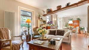 A cozy living room with a wooden coffee table, a comfortable sofa, and a bookshelf. - Villa Ester in Capannori (Capannori)