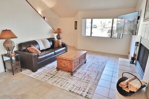 A living room with a sofa, coffee table, and a fireplace.